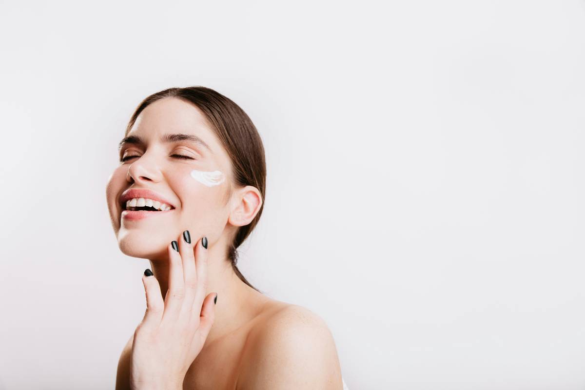 Woman applying moisturizer after shower as part of her body care routine for glowing skin