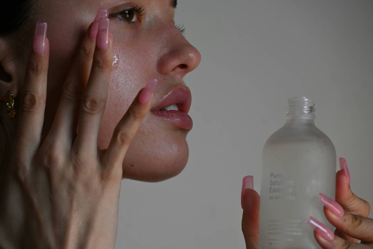 Woman applying moisturizer as part of her skincare routine for glowy skin